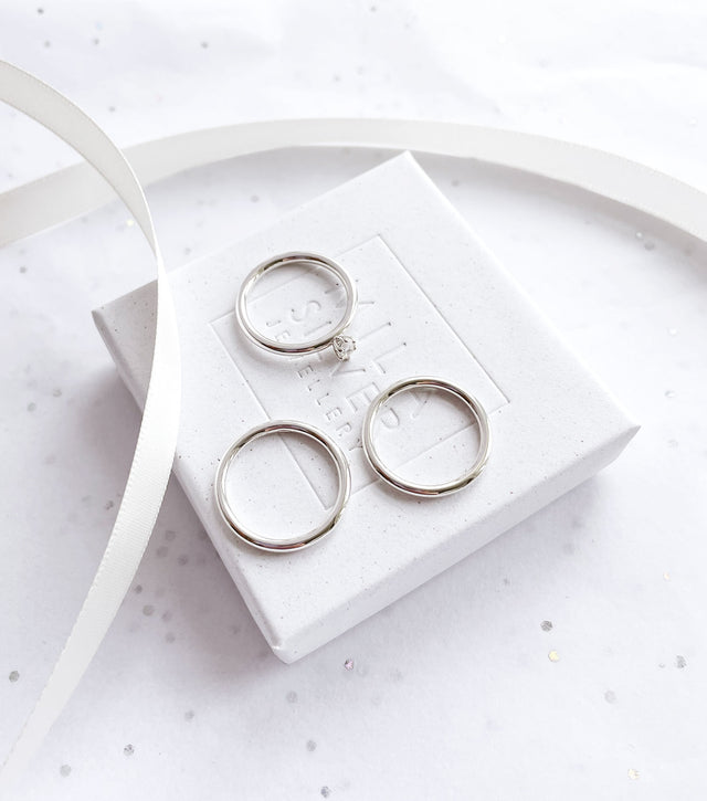 Tre silverringar placerade på en vit ask från Mila Silver.