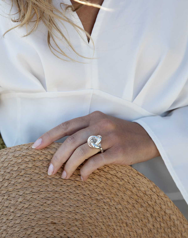 En tjej som bär en silverring med en stor knut.