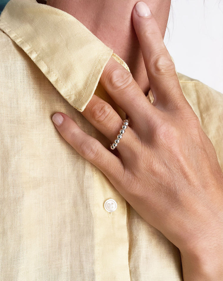 Tjej som bär en silverring med kulor.