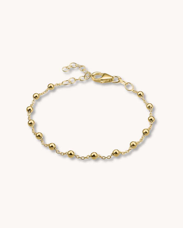 guldarmband med kedja och små kulor.