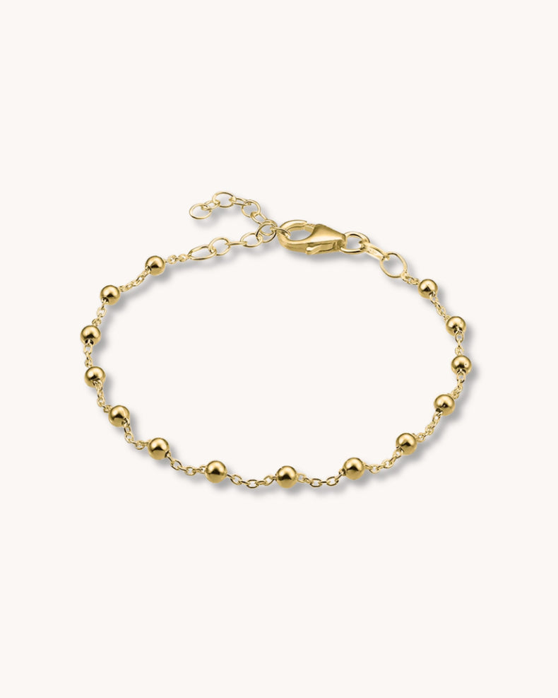 guldarmband med kedja och små kulor.