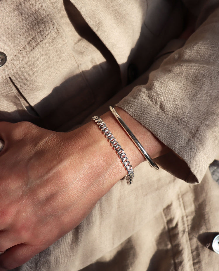 Man som bär ett kedjearmband i silver med pansarkedja.