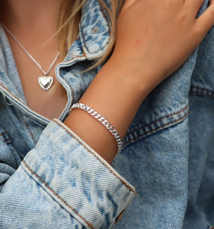 Tjej som bär ett kedjearmband med pansarlänk i silver.