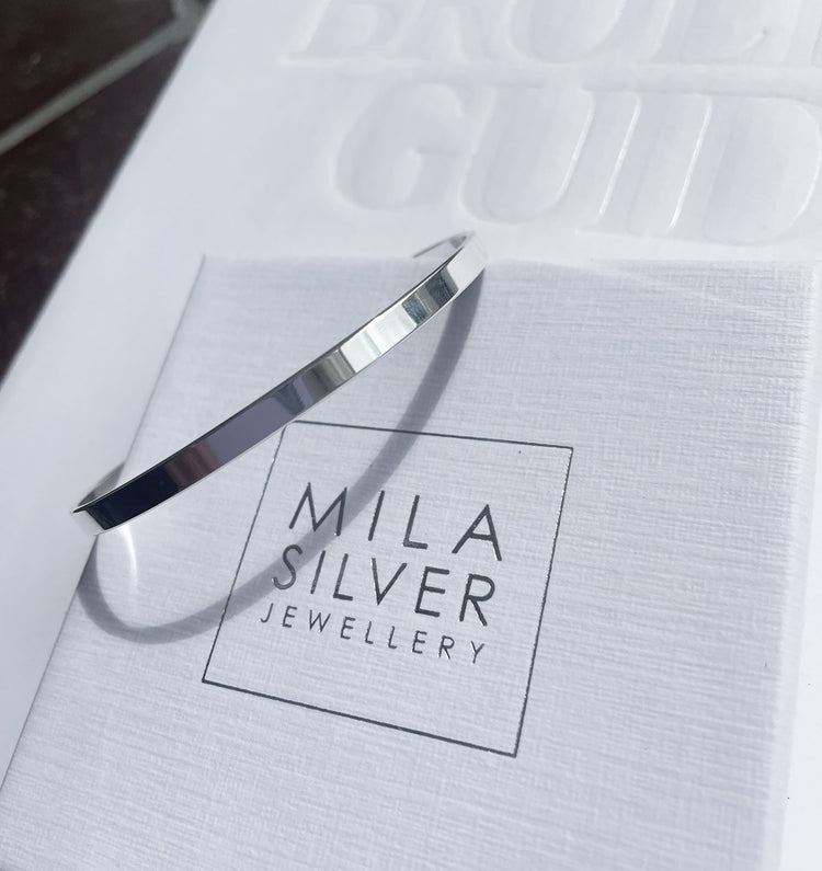 Stelt silverarmband som ligger på en Mila Silver ask.