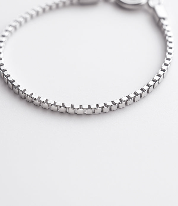 närbild på en box-kedja armband i silver