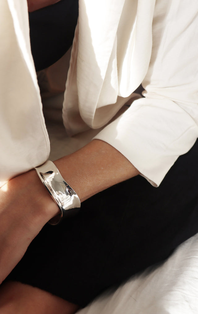 Tjej som bär ett brett stelt armband i äkta silver