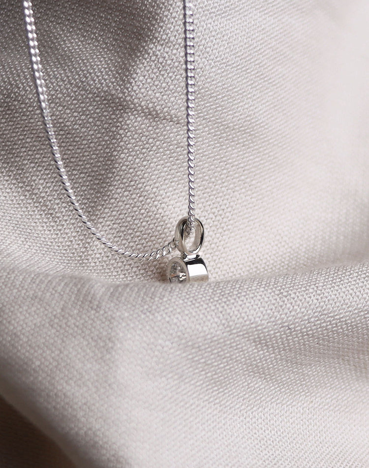 HÀngsmycke med diamant i rörfattning sett frÄn sidan.