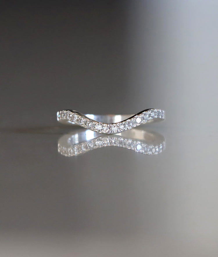 Ring i silver med ett band av små diamanter på rad.