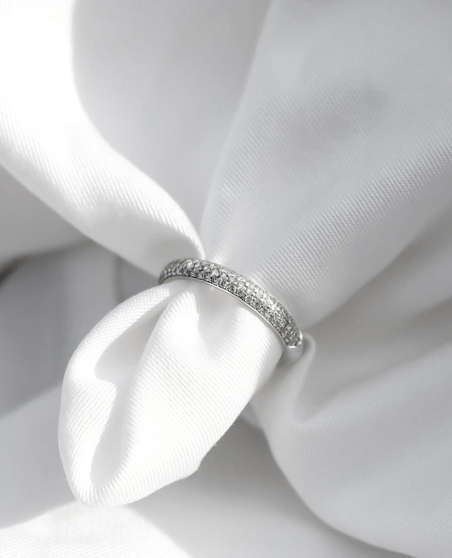 Alliansring i silver med mÄnga smÄ diamanter.