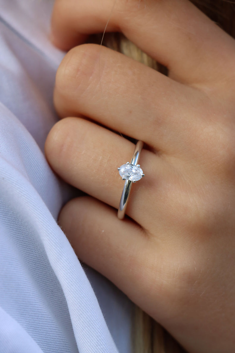 Kvinna som bär en förlovningsring i silver med oval diamant 0,5 ct.