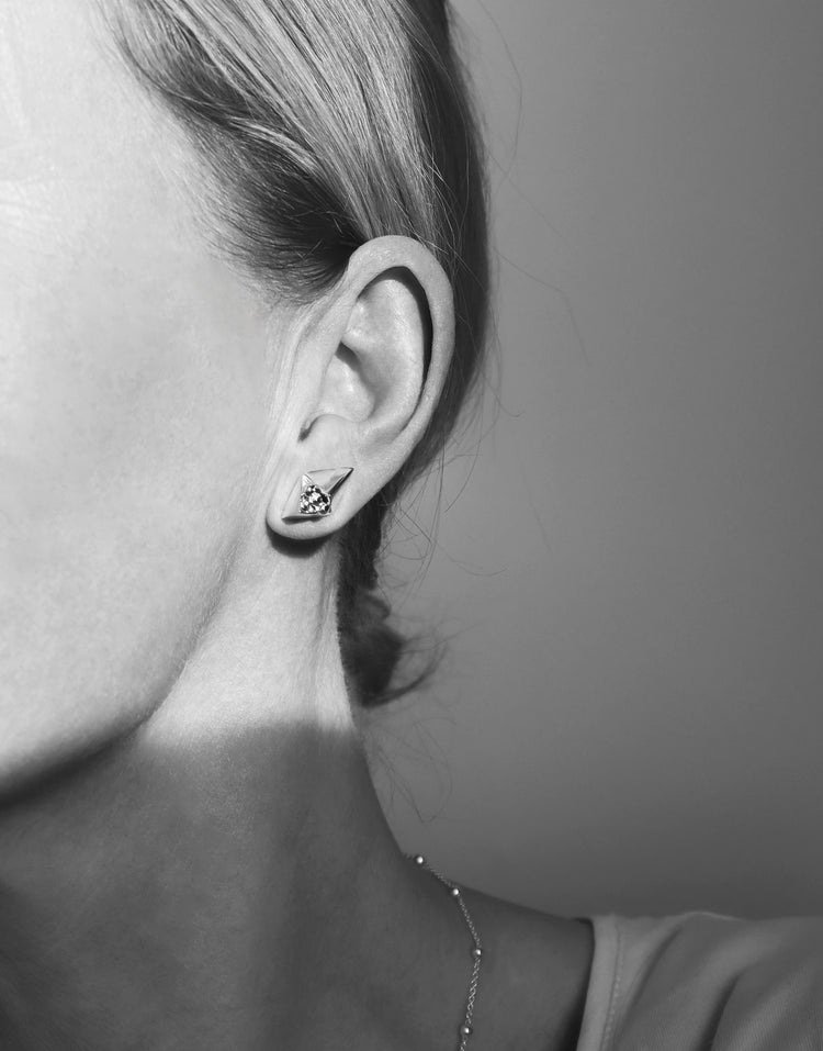 Tjej som bär silverörhängen med spetsar som pekar längs med örat.