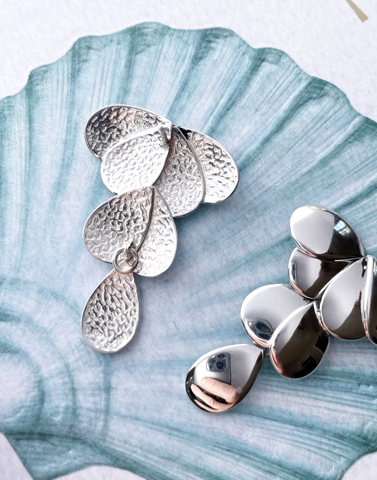 Örhängen I silver med hamrade baksidor och blanka framsidor.