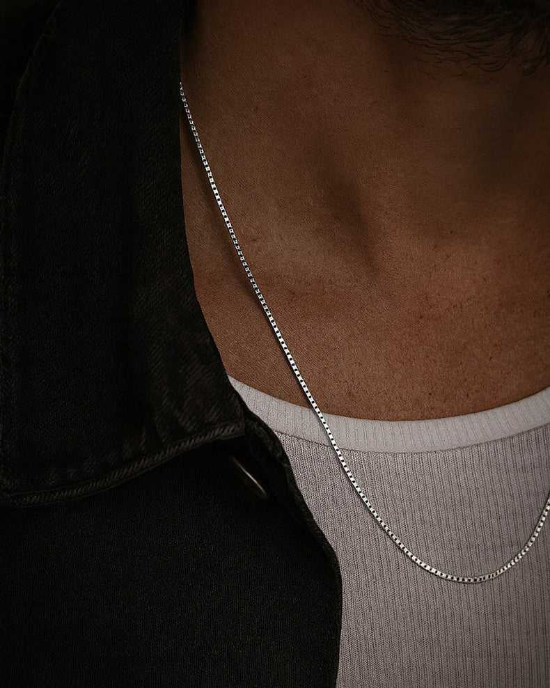Man som bär ett halsband med slät silverkedja - box kedja i äkta silver.