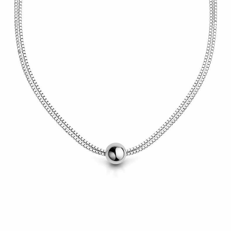 Silverhalsband till dam med dubbla kedjor som går genom en silverkula.