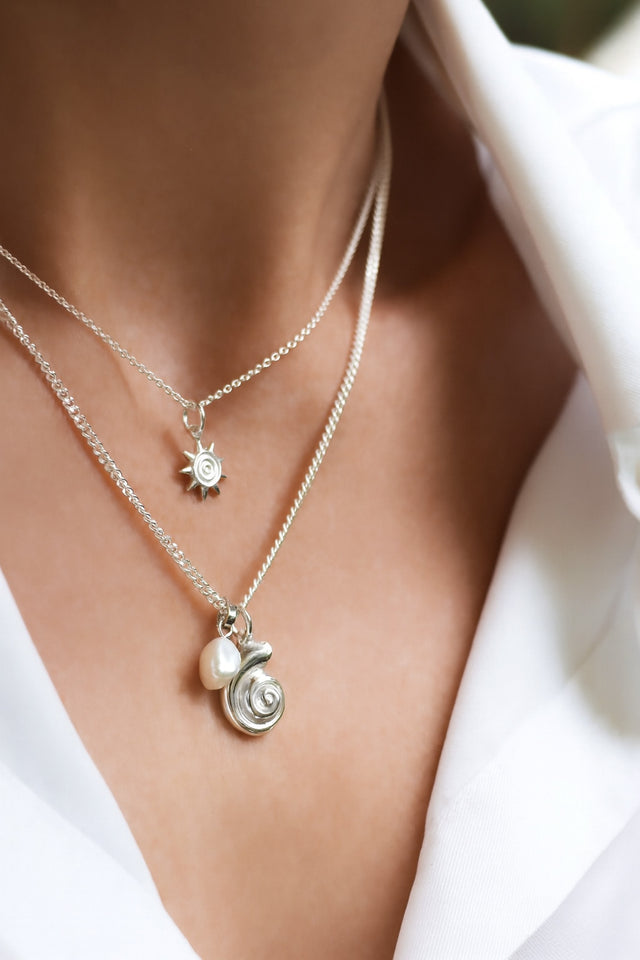 Silverhalsband med snäcka och pärla i kedja.