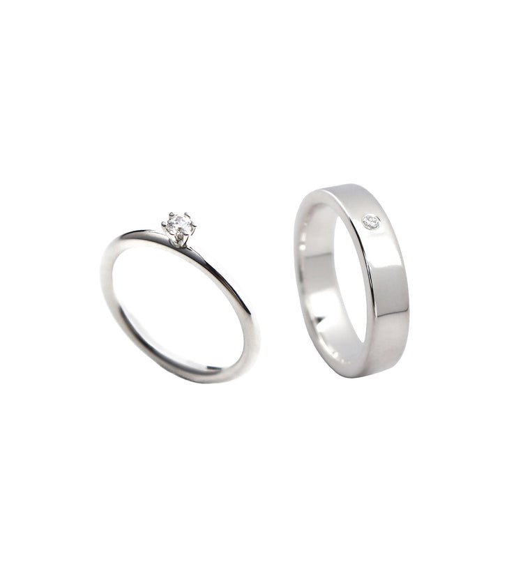 Ett set med vigsel/förlovningsring till henne och honom. En smal diamantring i silver med en diamant i krona och en bredare silverring med nedsänkt diamant.