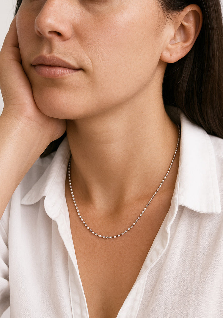 Kvinna som bär ett halsband med kulkedja i äkta silver.