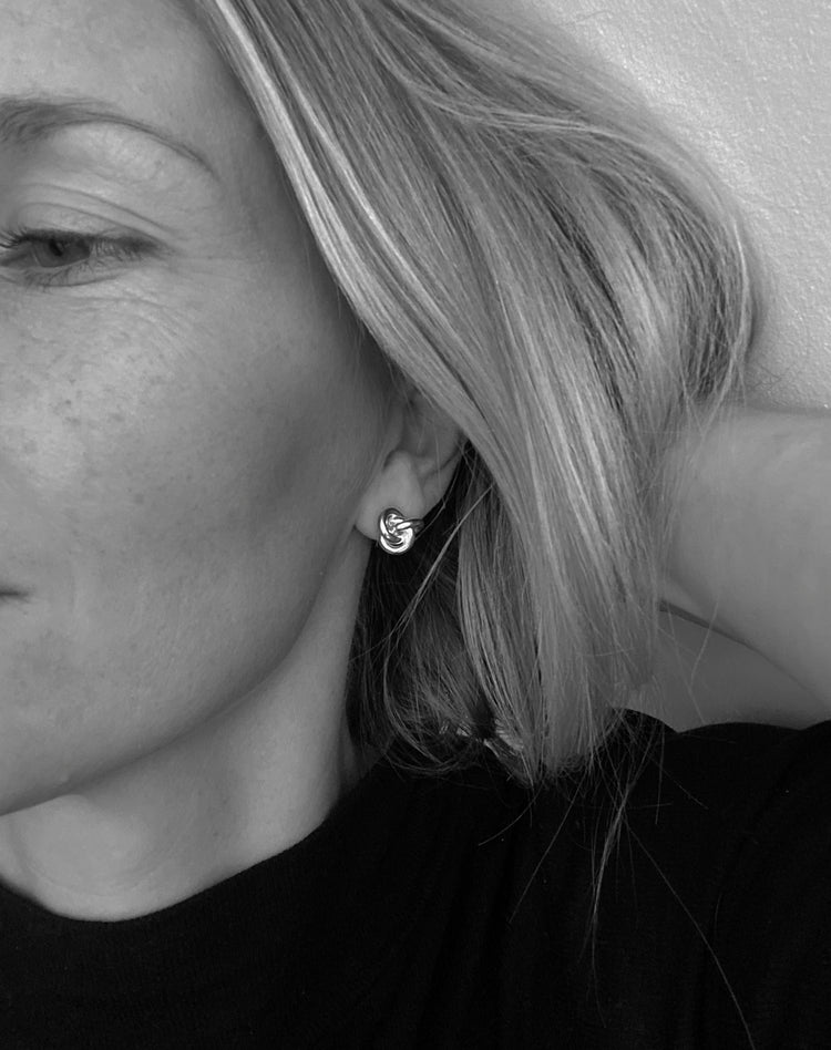 Tjej som bÀr stora knutar i öronen.