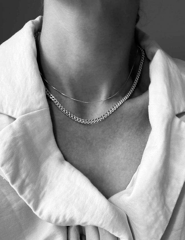 Tjej som bär ett halsband med 5 mm bred pansarkedja i silver.