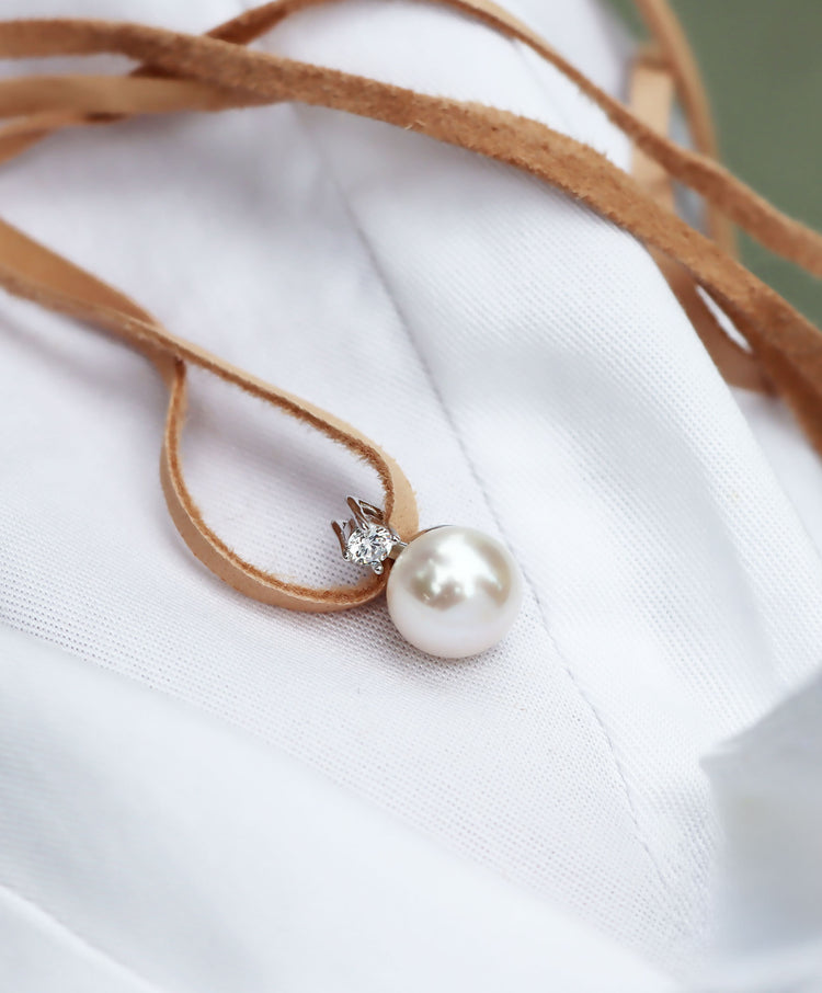 Pärlhalsband med naturfärgat läderband.