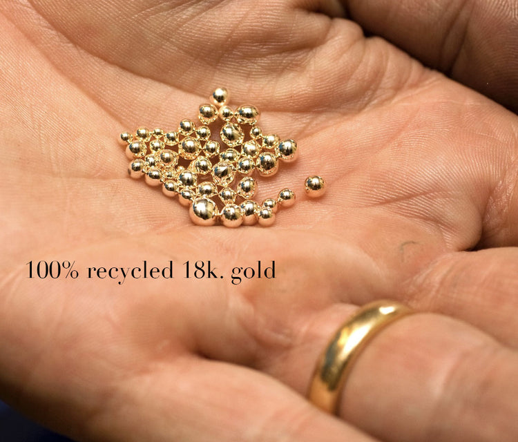 smÄ kulor av Ätervunnet guld i en handflata