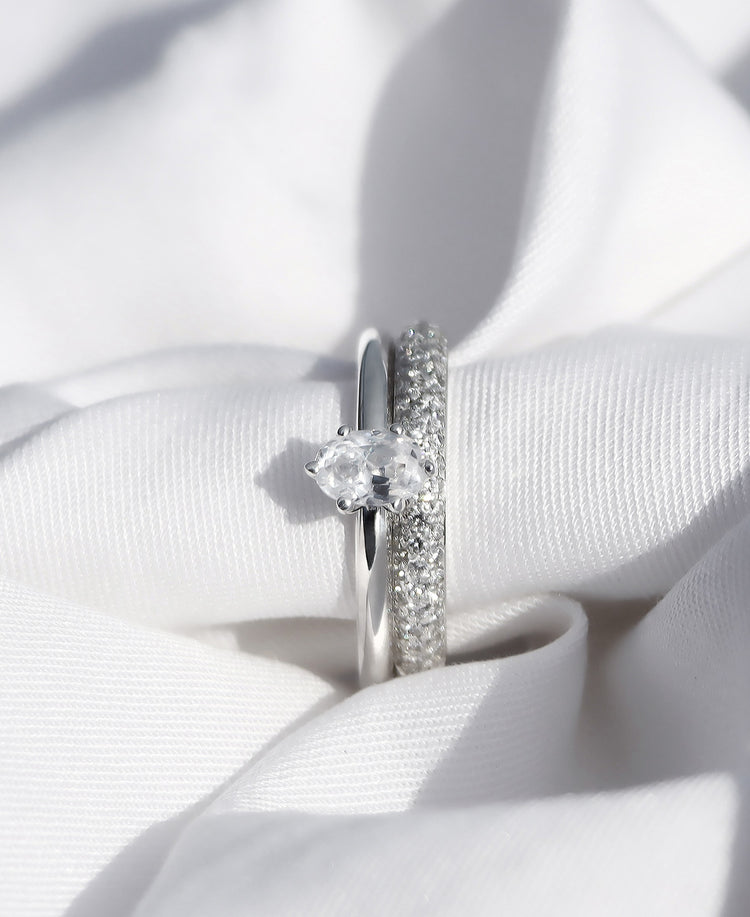 Set med vigselring och förlovningsring i silver med diamanter.