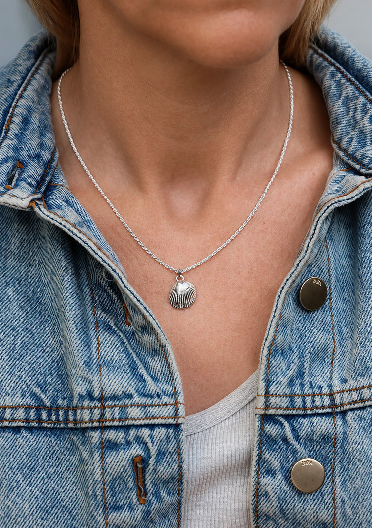 Kvinna som bär ett halsband i äkta silver med silversnäcka i repkedja.