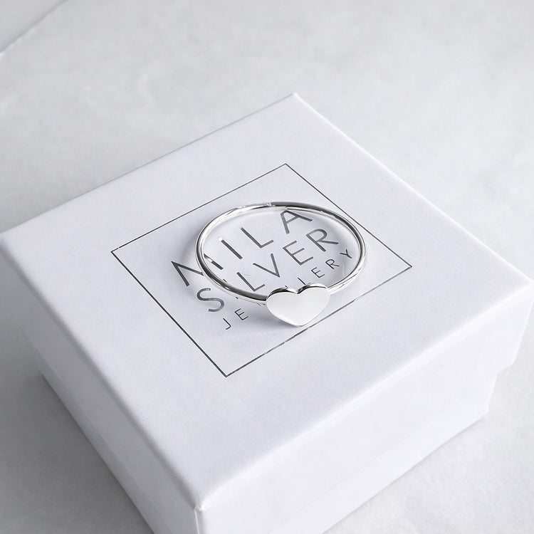 En ring i silver med ett hjärta placerad på en vit ask från Mila Silver.