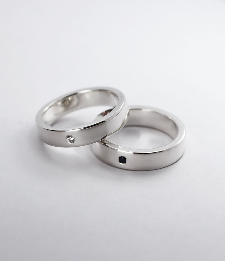 Två förlovningsringar i silver till mannen med svart och vit diamant.