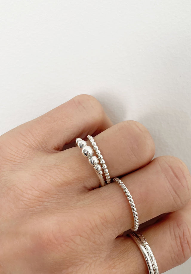 Flera silverringar som bärs på olika fingrar.