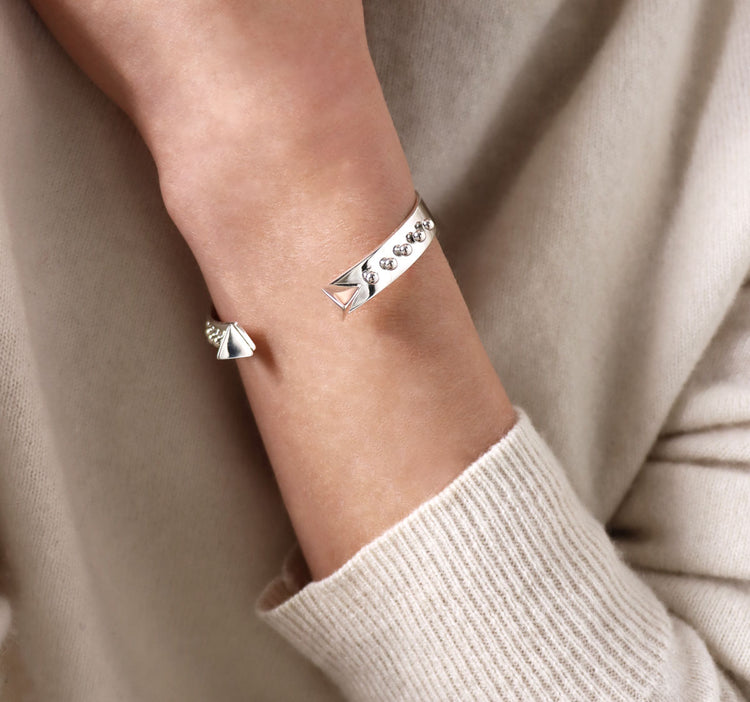 Tjej som bär ett cuff armband I silver med nitar och kulor.