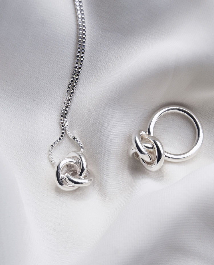 Halsband och ring med stora silverknutar.