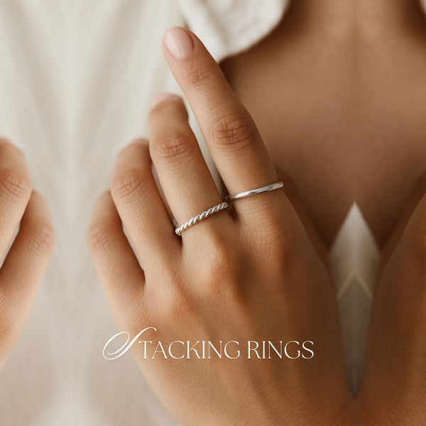 Tjej som bär två smala silverringar på olika fingrar - text på bild: Stacking Rings