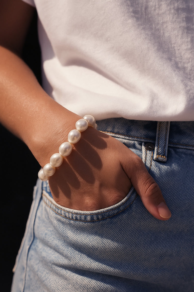 Tjej som bär ett stort pärlarmband til jeans och t-shirt. 