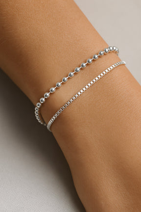 armband med kulkedja i silver kombinerat med ett annat silverarmband.