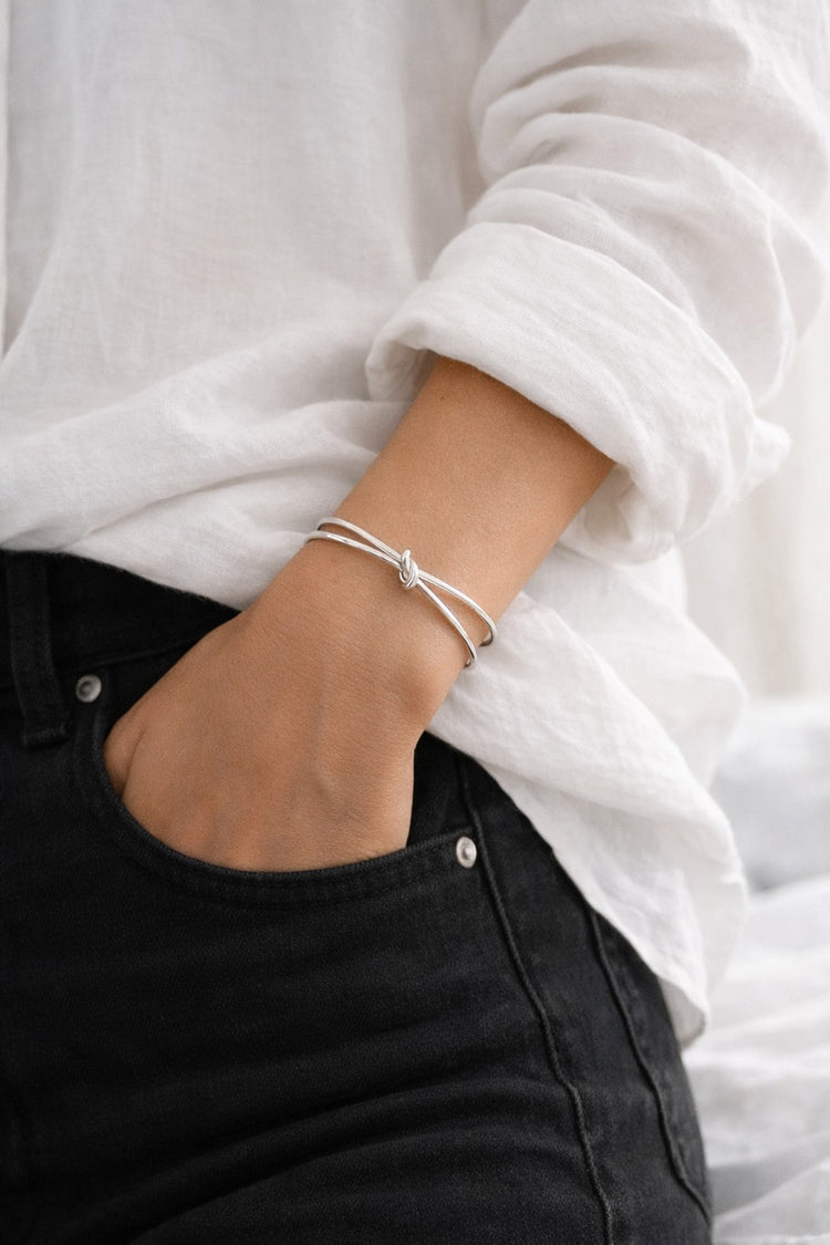 Kvinna som bär ett stelt armband med knut.