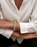 Kvinna som bär ett armband med tjock silverkedja. 