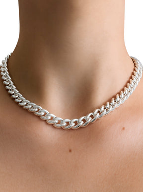 Tjej som bär ett chunky kedje halsband i äkta silver av modell Pansar. 
