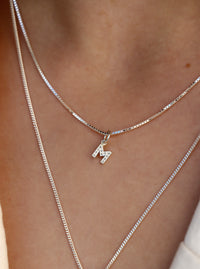 Halsband med bokstavsberlock i silver med diamanter. 