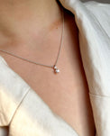 Tjej som bär ett halsband med diamant i fyrkantiga fattning. 