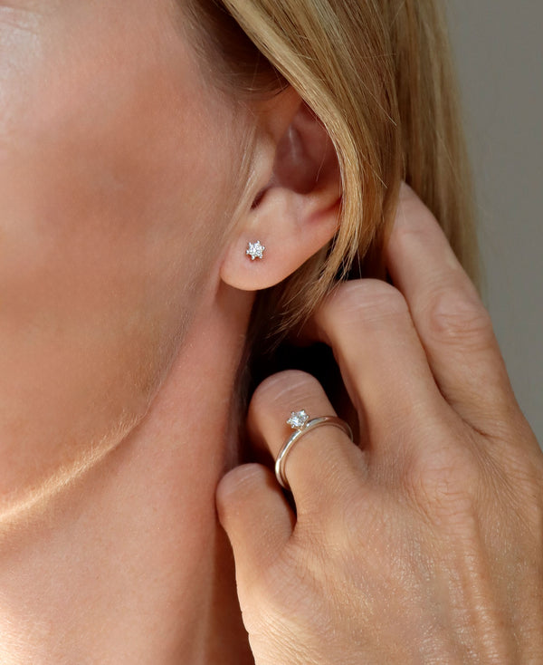 Tjej som bär diamantörhängen och diamantring. 