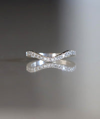 Ring i silver med ett band av små diamanter på rad.