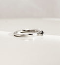 Silverring med svart diamant, sedd från sidan. Diamanten är infattad i krona. 