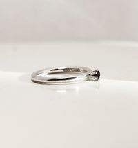 Silverring med svart diamant, sedd från sidan. Diamanten är infattad i krona. 