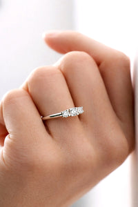 Kvinna som bär förlovningsring med tre diamanter. 