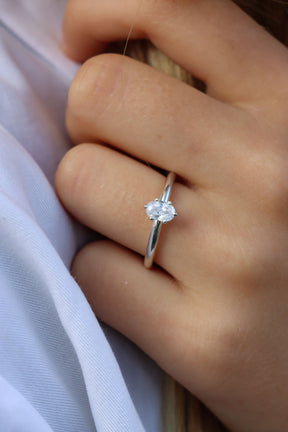 Kvinna som bär en förlovningsring i silver med oval diamant 0,5 ct.