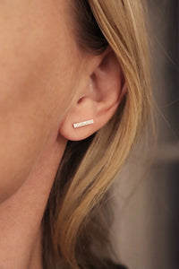 Tjej som bär örhängen med flera små diamanter i stavar