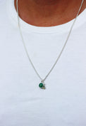 Man som bär ett halsband i silver med pansarkedja, grön jade-sten och bokstavsberlock G