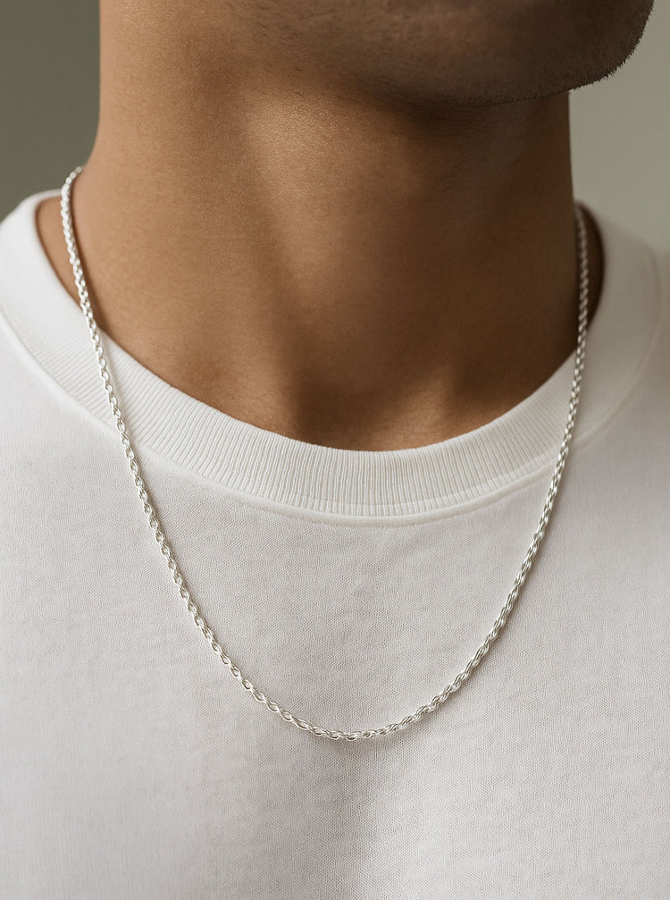 Man som bär ett halsband med en silverkedja av modell Rope Chain. 