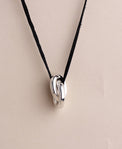Halsband med två ringar i silver i läderband. 